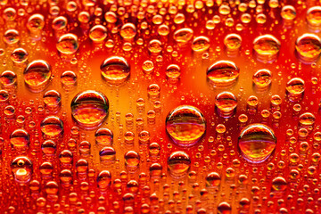 Water drops. Abstract red background. Colored macro texture with many drops. Iridescent wet gradient. Heavily textured image. Small depth of field. Selective focus