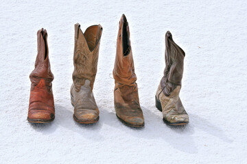 old worn cowboy boots on desert sand dune