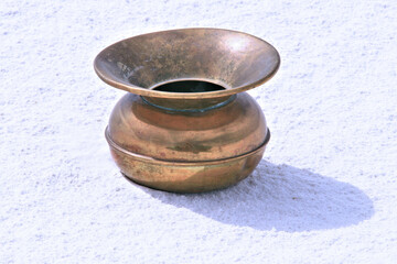 Old spittoon on desert sand dune