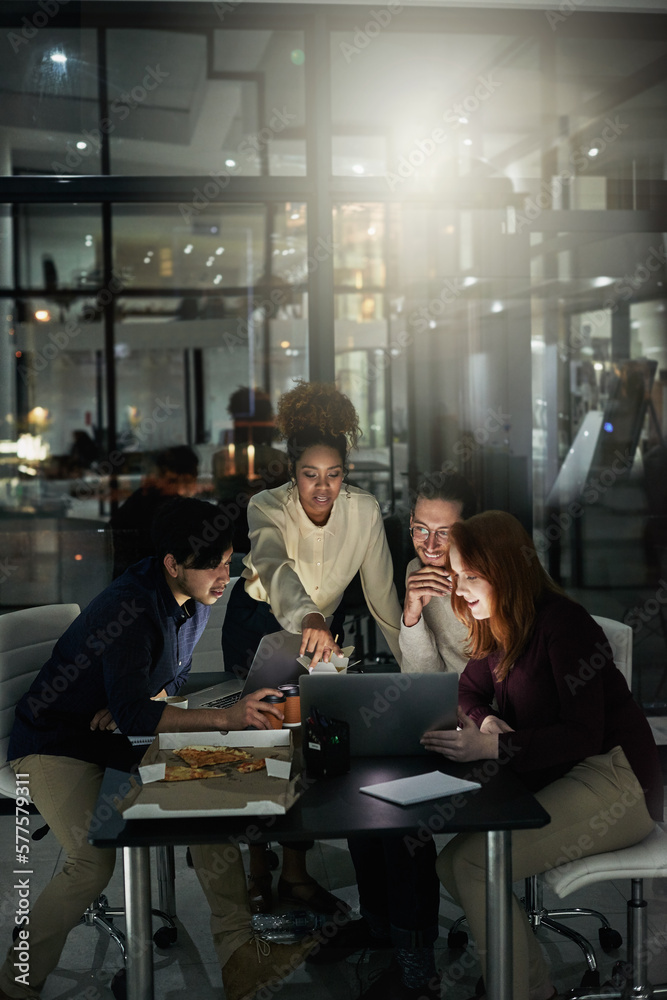 Poster designing your dreams. shot of a group of young designers working late in the office.