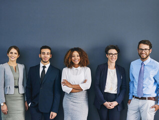 Weve each got our role to play. Studio shot of a group of businesspeople standing in line against a gray background.