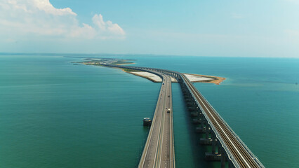 Top view of beautiful bridge over blue sea. Shot. Long highway with bridge over blue water. Bridge across strait between islands with beautiful seascape on sunny day