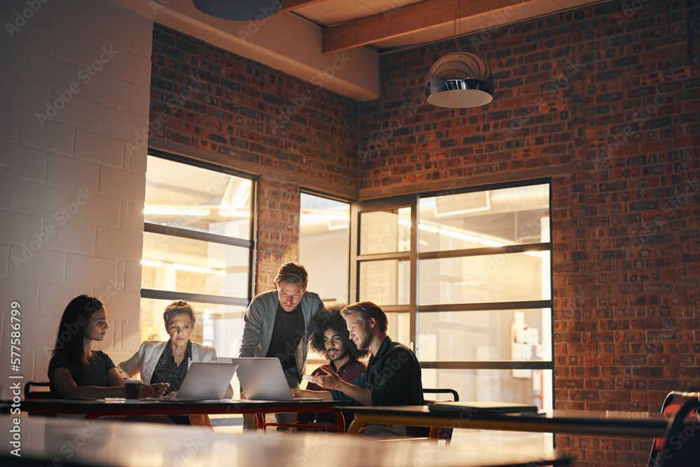 Poster Technology brings colleagues together. Shot of a group of designers having a brainstorming session in the boardroom.