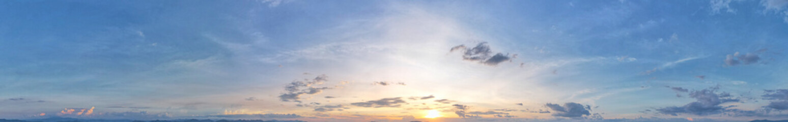 The blue sky was flooded by sunlight surrounded by slightly dark blue panoramic clouds.