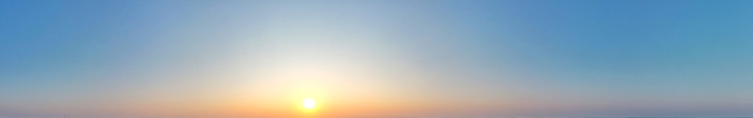 Panoramic of cloudless blue sky full of eveing sunlight.
