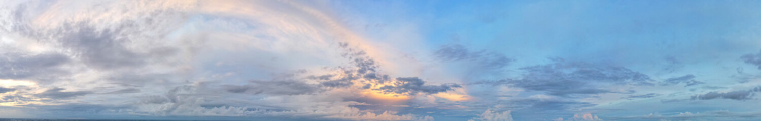 The blue sky is covered with soft blue and soft yellow clouds in sunset light.