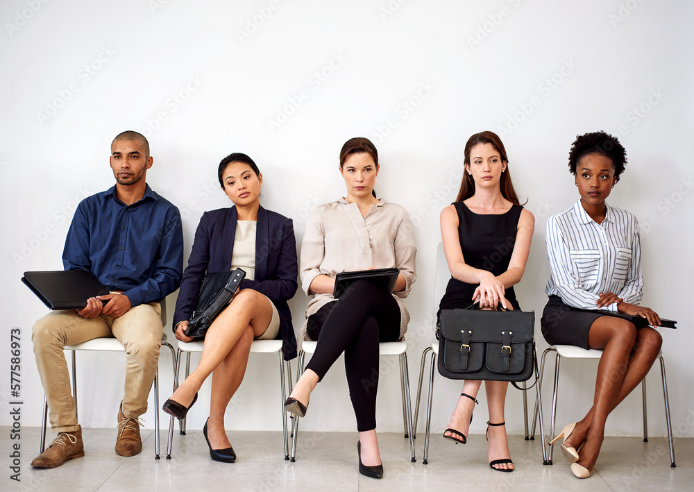 Poster Trying not to let the boredom get to them. Shot of a group of businesspeople seated in line while waiting to be interviewed.