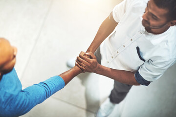 The warmest of welcomes. Shot of businesspeople shaking hands in an office.