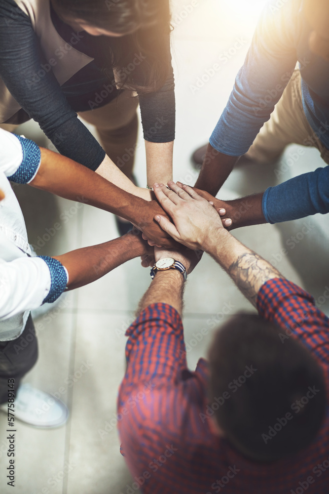 Poster taking it to the top together. cropped shot of a work group joining hands in solidarity.