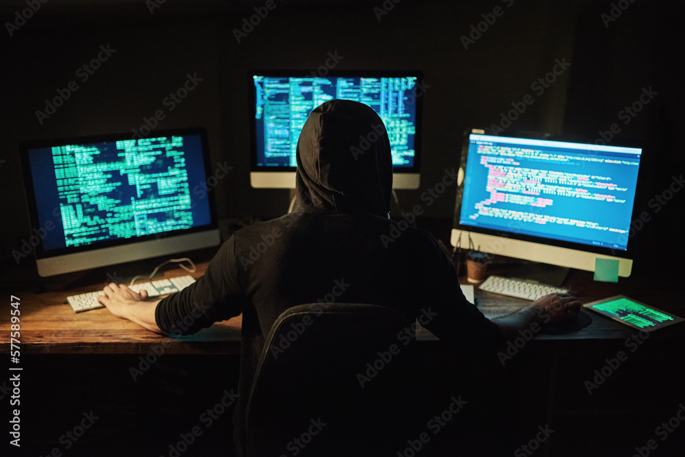 Poster Unraveling the code. Rearview shot of a young hacker cracking a computer code in the dark.