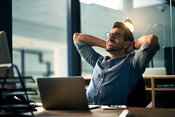 When the impossible became possible. Shot of a young businessman taking a break at his desk during...