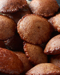 close-up view of deep fried sri lankan sweet called kevum or kavum, pile of traditional dessert made from rice flour and palm sugar or kithul sugar, full frame view in selective focus 