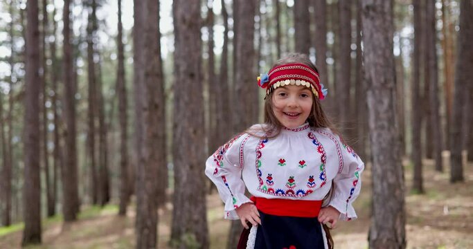 Girl in traditional ethnic costume dance bulgarian folklore horo, rachenitsa in a mountain forest. Bulgaria, heritage and culture, 4k slow motion video
