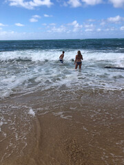 teenagers playing in the waves at the ocean