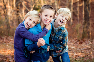 Obraz na płótnie Canvas Three elementary aged boys laughing and smiling at the camera