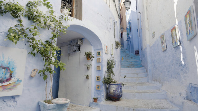 Beautiful narrow streets of Greece. Action. Decorative elements, paintings and plants.