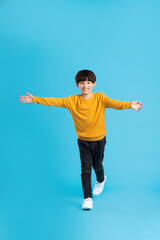 Fototapeta na wymiar full body image of asian boy posing on blue background