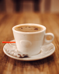 Taza de cafe sobre mesa de madera con fondo claro
