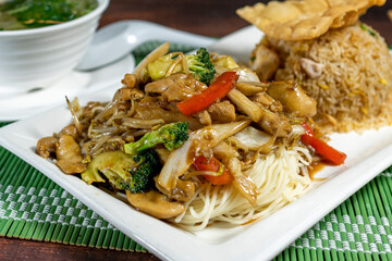 Stir-fried noodles with chicken and vegetables with chaufa rice. Wantan soup. Peruvian Chinese food. Chifa