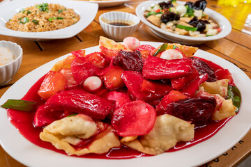 kam lu wantan with chaufa rice, skewering the meat with a fork. peruvian chinese food