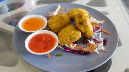 Fried stuffed tofu and chili sauce in a plate served at the table