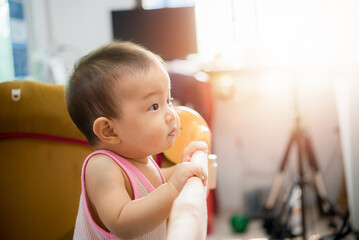 Cute little baby Standing in cradle at home, Asia baby in crib with windows light in home