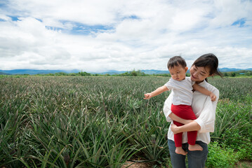 Mother and baby daughter in pineapple farm