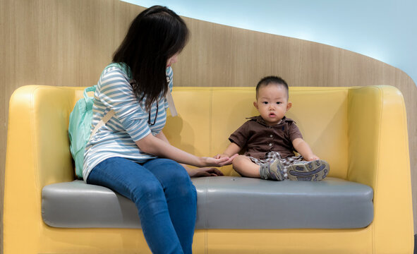 Happy young woman with her little baby in a shopping mall