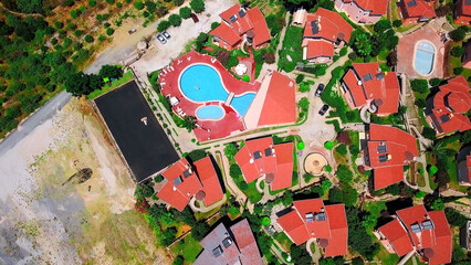 Aerial top view of small villas and open air swimming pool. Clip. Concept of summer holidays and tourism.