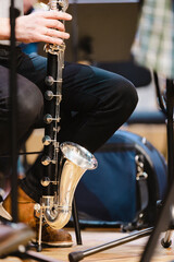 A musician playing a bass clarinet in a casual wind ensemble rehearsal