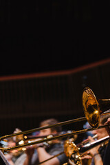 A musician playing a trombone during a casual wind ensemble rehearsal just before the concert