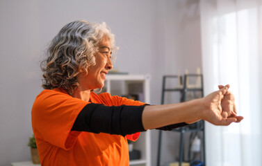 Fitness mature woman in sport clothes exercising at home. Retirement, fitness, healthy lifestyle, sport and activity concept.