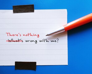 Note stick on blue background with pen writing Whats wrong with me, changed to There's nothing...