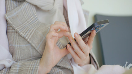 Fototapeta na wymiar Finger of woman touching, scrolling page on mobile phone. Action. Close up of woman using phone.