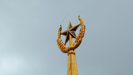Soviet symbol, golden spire on a cloudy sky background. Stock footage. Golden star and ears of wheat.