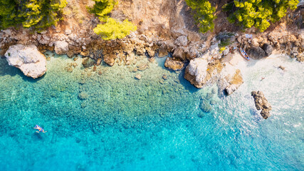 Take in the breathtaking aerial view of Makarska Riviera in Croatia, revealing a picturesque rocky beach and the vibrant turquoise water.