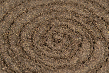 Fototapeta na wymiar Spiral poured ground black pepper background. Dry seasoning pepper. Spices and herbs for cooking, pepper powder