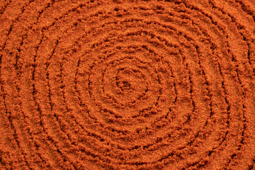 Fototapeta na wymiar Spiral poured paprika spice powder background. Dry seasoning Paprika. Spices and herbs for cooking, bell pepper