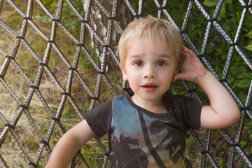 A baby is lying on a hammock. Eyes wide open.