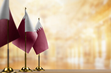 Small flags of the Qatar on an abstract blurry background