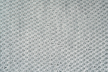 Knitted warm white fabric or sweater. Cozy textile background in the home atmosphere. Wool fabric texture close up backdrop. Comfortable style clothing. Wavy folds material