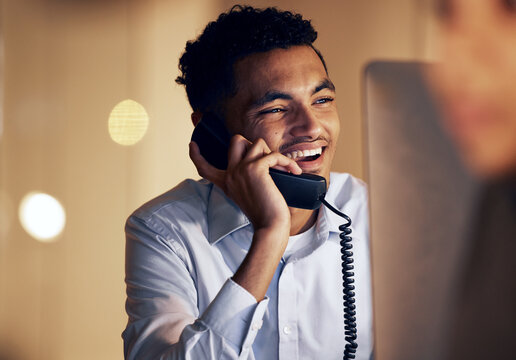 Telephone, Night And Businessman On A Phone Call In The Office Talking While Working On A Computer. Discussion, Communication And Professional Male Employee Speaking On A Landline In The Workplace.