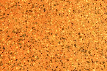 Concrete orange floor with multicolor marble and small natural crushed stones inserted. Pebbles textured background. Decorative rough surface granite. Gravel wall material. Little rock backdrop
