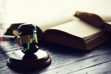 Wooden judge gavel and legal book on wooden table