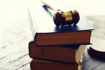 Wooden judge gavel and legal book on wooden table