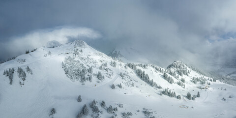 Fototapeta na wymiar view of freshly snow-covered ski slopes in the morning sun in tyrolean winter tourism mountain hahnenkamm