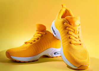 pair of yellow sneakers on yellow background. copy space