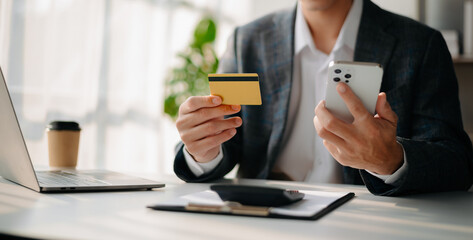 Man using smart phone for mobile payments online shopping,omni channel,sitting on table