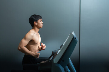 Asian man big muscle running on a treadmill at fitness center,Male athlete workout on running...