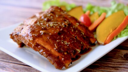 Top view grilled and smoked pork ribs with barbeque sauce on a carving board.